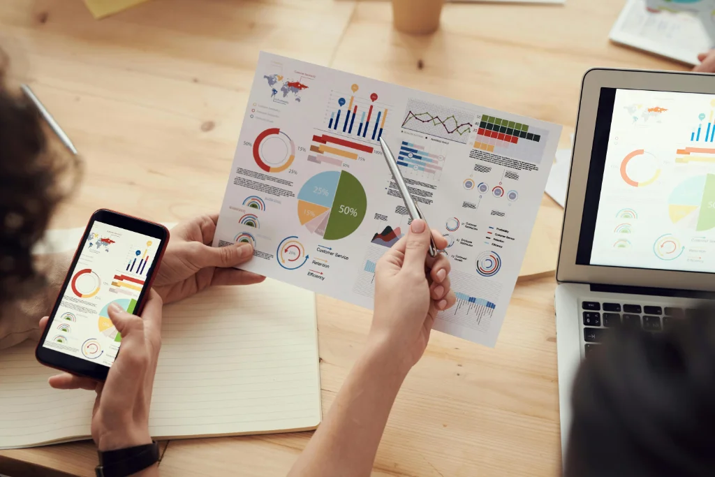 Analyse de graphiques financiers sur smartphone et documents